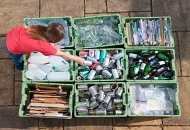 Mujer haciendo reciclaje en diferentes cajas