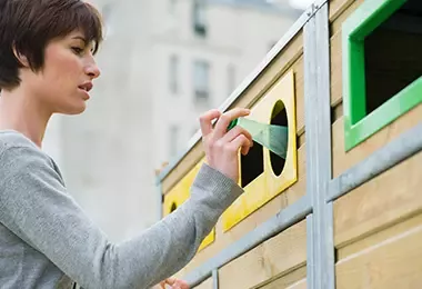 Mujer reciclando botellas de plástico